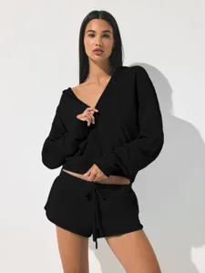 Detail shot of women's black zip-up cropped hoodie and matching sport shorts set.