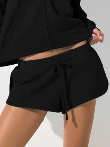 Detail shot of black zip-up hoodie and athletic shorts set, casual streetwear style.