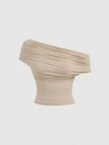 Beige off-shoulder draped top detail, elegant one-shoulder design, soft fabric close-up.