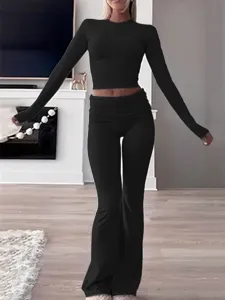 Black long sleeve crop top and flare pants set detail, comfortable casual workout wear.