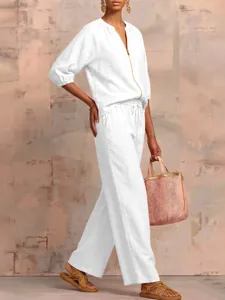 Casual summer two piece outfit featuring a white zip top and wide leg pants for women.