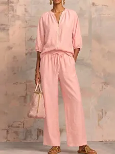 Detail shot of a casual pink two-piece set featuring a zip top and wide-leg pants.