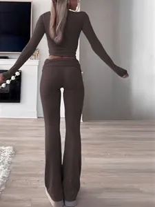 Back view detail of women brown long sleeve crop top and matching flare pants activewear set.