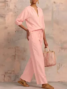 Detailed view of the pink casual two-piece pants set with zip collar and chic handbag.