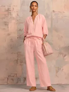 Pink two piece set detail featuring zip front top and wide leg trousers for summer.
