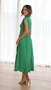 Detail shot of a stylish green mock neck midi dress with chic waist cutouts, perfect summer look.