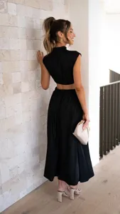 Elegant black mock neck crop top and matching long skirt two-piece set, solid color cutout style.