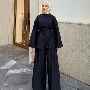 Ansicht des lässigen einfarbigen Langarm-Tops mit Taillierung und der weiten Hose.