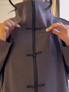 Grey high-collar jacket detail showcasing traditional Chinese frog buttons and front zipper.