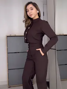 Detailansicht des braunen Damen Zweiteilers mit Stehkragen Oberteil und langer Hose.