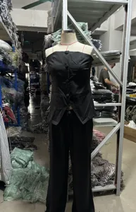 Detailansicht des schwarzen trägerlosen Sets mit Knöpfen, das lässige Eleganz zeigt.