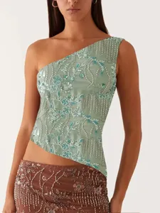 Gros plan détaillé du haut asymétrique et de la jupe tendance brodés de perles et de sequins.