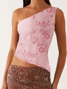 Vue détaillée du haut asymétrique rose brodé de perles et de sequins avec jupe assortie.