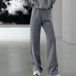 Detalle de chándal gris lavado, pantalón ancho cómodo con costura central y sudadera.