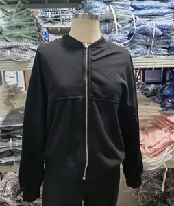 Vista detallada de conjunto deportivo negro liso para mujer con cremallera casual.