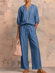 Detailed view of women's casual solid color zip-up top and wide leg pants set outfit.