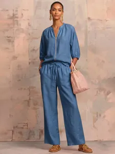 Blue linen blend two-piece set detail, featuring a zip-up top and wide-leg trousers.