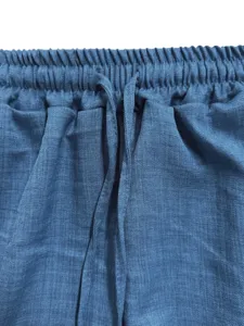 Close-up of blue casual pants elastic waistband with drawstring detail, soft textured fabric.
