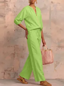 Summer casual loose green zip top and wide leg trousers outfit apparel detail view.