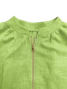 Close-up detail of women light green top featuring zipper collar and breathable textured fabric.