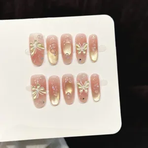 Primo piano dettagliato di unghie press-on rosa nude cat-eye con farfalla 3D e perle