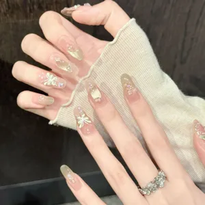Unghie finte fatte a mano con effetto occhio di gatto rosa nude e farfalla 3D brillante.