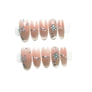 Faux ongles faits main rose nude effet œil-de-chat avec des strass et cristaux bleus