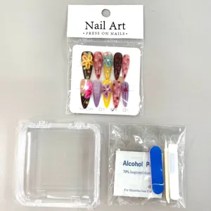 Handmade press-on nail set detail view with floral rhinestone art, storage box and tool kit.