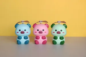 Détail de mini ventilateurs cochons de dessin animé mignons avec des chapeaux à hélice colorés.