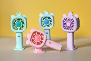 Primo piano del mini ventilatore USB portatile con design orso corona dettagli scrivania.