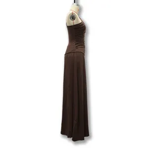 Side detail of a brown one-shoulder pleated maxi dress, elegant and stylish fabric texture.