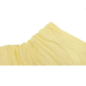 Close-up detail of yellow pleated chiffon fabric showing exquisite texture and soft material.