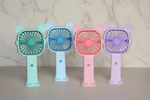 Gros plan de ventilateurs portatifs colorés avec oreilles d'ours mignonnes et base de bureau.