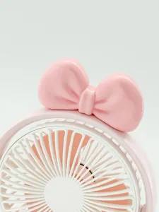 Gros plan sur le joli nœud rose décoratif du mini ventilateur de bureau portable, blanc.