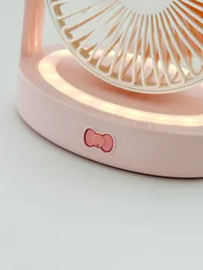 Gros plan détaillé du ventilateur de bureau rose montrant le bouton nœud et la lumière LED.
