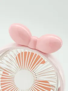 Gros plan détaillé de la jolie décoration de nœud rose sur le ventilateur de bureau portable.
