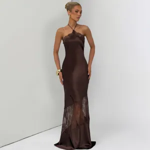 Close-up of elegant brown halter long dress featuring sheer lace patchwork and silk texture.