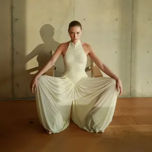 Detail shot of women halter ruched backless loose jumpsuit in elegant off white design.