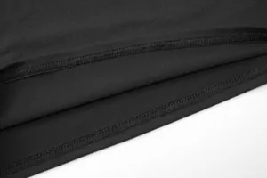 Detaillierte Nahaufnahme des schwarzen Bekleidungssaums mit sauberer Overlock-Naht Textur.