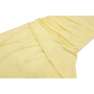 Detail shot of pale yellow one-shoulder pleated chiffon dress fabric showing exquisite texture.
