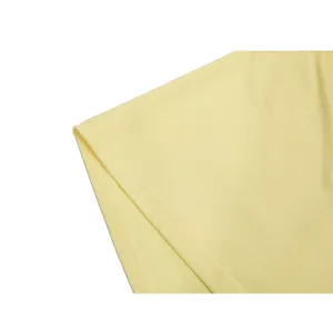 Yellow chiffon dress hem detail, fine stitching workmanship, smooth lightweight fabric.