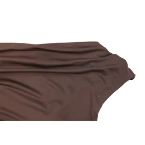 Detail shot of the brown one-shoulder asymmetrical neckline dress fabric with delicate pleats.