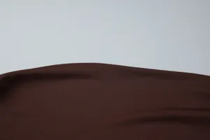 Detailed close-up view of the smooth brown fabric texture, highlighting fine textile quality.