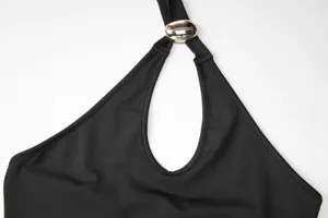 Detailed view of a black halter neck dress featuring a gold metal ring and cutout design.