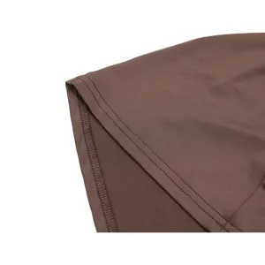 Close up detail view of brown chiffon dress fabric stitching, fine hemline craftsmanship.
