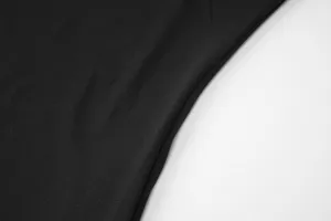 Close-up view of premium black dress fabric showing detailed texture and fine stitching work.