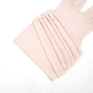 Detail view of a light pink sleeveless halter ruched bodycon mini dress, stylish texture.