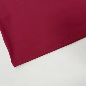 Close-up detail shot of the dark red fabric hem and fine double-needle stitching quality