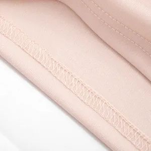 Close-up detail of smooth pink fabric and fine stitching for summer women's dress.