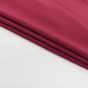 Burgundy ribbed fabric detail texture close up shot, soft and elastic material showcase.